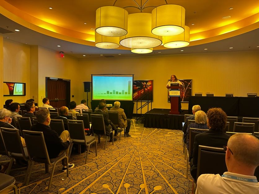 Wide view of the ICMC 2026 session room, audience seated, Tim onstage